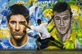 A youngster plays football in front of a mural of Argentine football player Lionel Messi (L) and Brazil's player Neymar da Silva Santos Junior at a field of Tavares Bastos shantytown (favela) in Rio de Janeiro, Brazil. (YOSHI CHIBA/AFP/Getty Images)