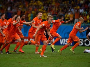 Netherlands players celebrate after the quarter-final football match between the Netherlands and Costa Rica at the Fonte Nova Arena in Salvador during the 2014 FIFA World Cup on July 5, 2014.  AFP PHOTO / ODD ANDERSENODD ANDERSEN/AFP/Getty Images