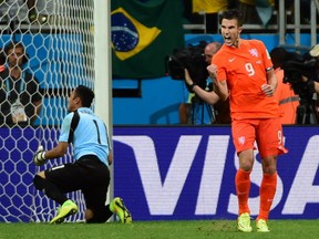 Netherlands' forward and captain Robin van Persie (R) celebrates after scoring past Costa Rica's goalkeeper Keylor Navas during the penalty shootout. RONALDO SCHEMIDT/AFP/Getty Images