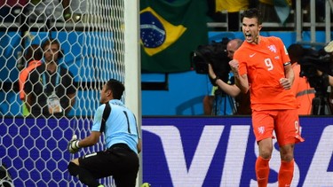 Netherlands' forward and captain Robin van Persie (R) celebrates after scoring past Costa Rica's goalkeeper Keylor Navas during the penalty shootout. RONALDO SCHEMIDT/AFP/Getty Images