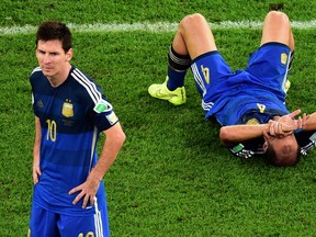 Argentina's Pablo Zabaleta lies on the pitch as Lionel Messi stands beside him after their 1-0 loss to 
Germany in the World Cup final at the Maracana Stadium in Rio de Janeiro, Brazil, on Sunday.