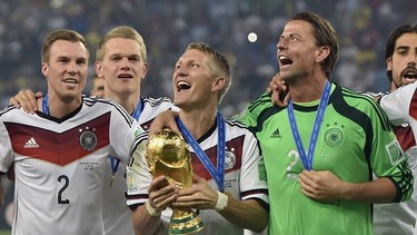 Germany's Bastian Schweinsteiger celebrates with the trophy after the World Cup final soccer match between Germany and Argentina at the Maracana Stadium in Rio de Janeiro, Brazil, Sunday, July 13, 2014. Germany won the match 1-0.   (AP Photo/Martin Meissner)