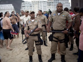 Police stand guard as Argentina soccer fans gather on Copacabana beach during the World Cup in Rio de Janeiro, Brazil, Friday, July 11, 2014. Argentina will face Germany at the final World Cup match on Sunday. (AP Photo/Rodrigo Abd)