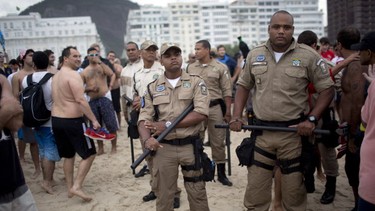 Police stand guard as Argentina soccer fans gather on Copacabana beach during the World Cup in Rio de Janeiro, Brazil, Friday, July 11, 2014. Argentina will face Germany at the final World Cup match on Sunday. (AP Photo/Rodrigo Abd)