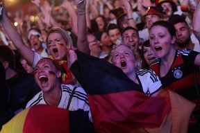 German soccer fans celebrate after their team won the Brazil World Cup semi final being played in Belo Horizonte, Brazil, between Germany and Brazil at a public viewing event called 'Fan Mile' in Berlin, Tuesday, July 8, 2014. (AP Photo/Markus Schreiber)