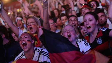 German soccer fans celebrate after their team won the Brazil World Cup semi final being played in Belo Horizonte, Brazil, between Germany and Brazil at a public viewing event called 'Fan Mile' in Berlin, Tuesday, July 8, 2014. (AP Photo/Markus Schreiber)