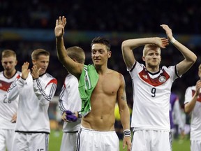 Germany's Mesut Ozil, left, and teammate Andre Schuerrle (9) celebrate after Germany defeated Algeria 2-1 in extra time during the World Cup round of 16 soccer match between Germany and Algeria at the Estadio Beira-Rio in Porto Alegre, Brazil, Monday, June 30, 2014. (AP Photo/Kirsty Wigglesworth)