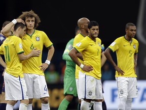 Brazil's David Luiz (L) and Oscar console each other alongside Hulk (C) and Fernandinho (R) after the Netherlands 3-0 victory over Brazil. (Natacha Pisarenko/AP)