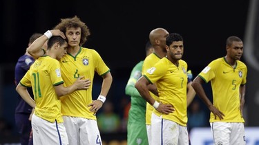 Brazil's David Luiz (L) and Oscar console each other alongside Hulk (C) and Fernandinho (R) after the Netherlands 3-0 victory over Brazil. (Natacha Pisarenko/AP)