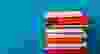 Stack of colorful books, grungy blue background, free copy space