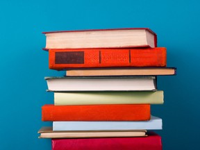 Stack of colorful books, grungy blue background, free copy space