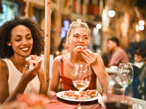Women sitting at a restaurant, eating and smiling