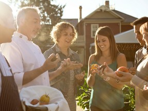 A group inspects tomatoes at Rouge Restaurant on Alberta Food Tours tour of Calgary's Inglewood neighbourhood