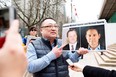 Protester Louis Huang of Vancouver Freedom and Democracy for China holds photos of Canadians Michael Spavor and Michael Kovrig,