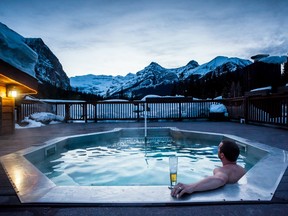 A man relaxes in a hot tub at Deer Lodge in Lake Louise Alberta
