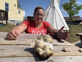 Sarah Myers shows off the bannock she just cooked in a fire pit.