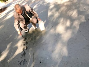 A man enjoys the fleeting art of water calligraphy in Xiangyang Park.