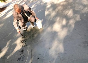 A man enjoys the fleeting art of water calligraphy in Xiangyang Park.