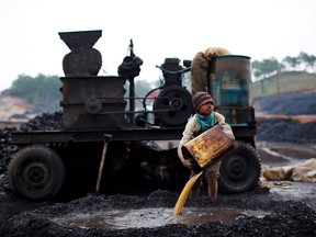 A boy works at a coal depot in India. Children are already bearing the brunt of climate change