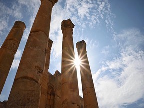 The sun peeks through ancient columns at Jerash