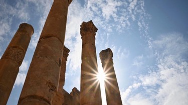 The sun peeks through ancient columns at Jerash