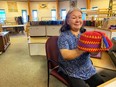 Weaver/printmaker Eena Angmarlik shows off a Pang hat at the Uqqurmiut Centre for Arts & Crafts.