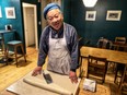 Siu To, inside his Green Onion Cake Man shop, prepares to cut his stuffed roll into eight "cakes."