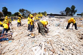 Workers remove rubble from a destroyed school in Port-au-Prince