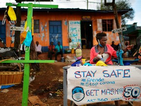 A local artist makes and sells face masks made from cloth in the Kibera slum in Nairobi