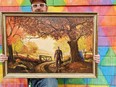 David Sherrill poses with a painting of Michael Myers, the antagonist in the Halloween franchise, painted against a serene fall background.