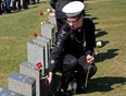 A sea cadet places a flower on a grave marker at a memorial service at Fairview Lawn Cemetery to mark the 100th anniversary of the sinking of RMS Titanic in Halifax on Sunday, April 15, 2011.