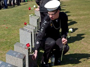 A sea cadet places a flower on a grave marker at a memorial service at Fairview Lawn Cemetery to mark the 100th anniversary of the sinking of RMS Titanic in Halifax on Sunday, April 15, 2011.