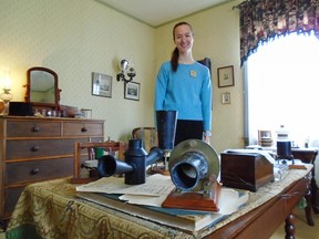 Bell Homestead guide Jillian with some of the telephone prototype replicas in Alexander's study.
