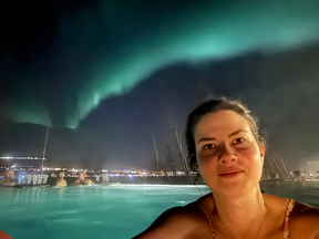 Taking a very-precarious Northern Lights photo in the Forest Lagoon hot spring.