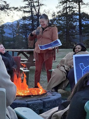 An image of Matricia Bauer of Warrior Women doing a fireside drumming and stargazing experience in Jasper, Alberta, Canada.