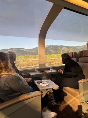 An image of three people taking in the views from the glass-dome coach on the Rocky Mountaineer train during the Journey Through the Clouds trip through the Canadian Rockies in Canada.