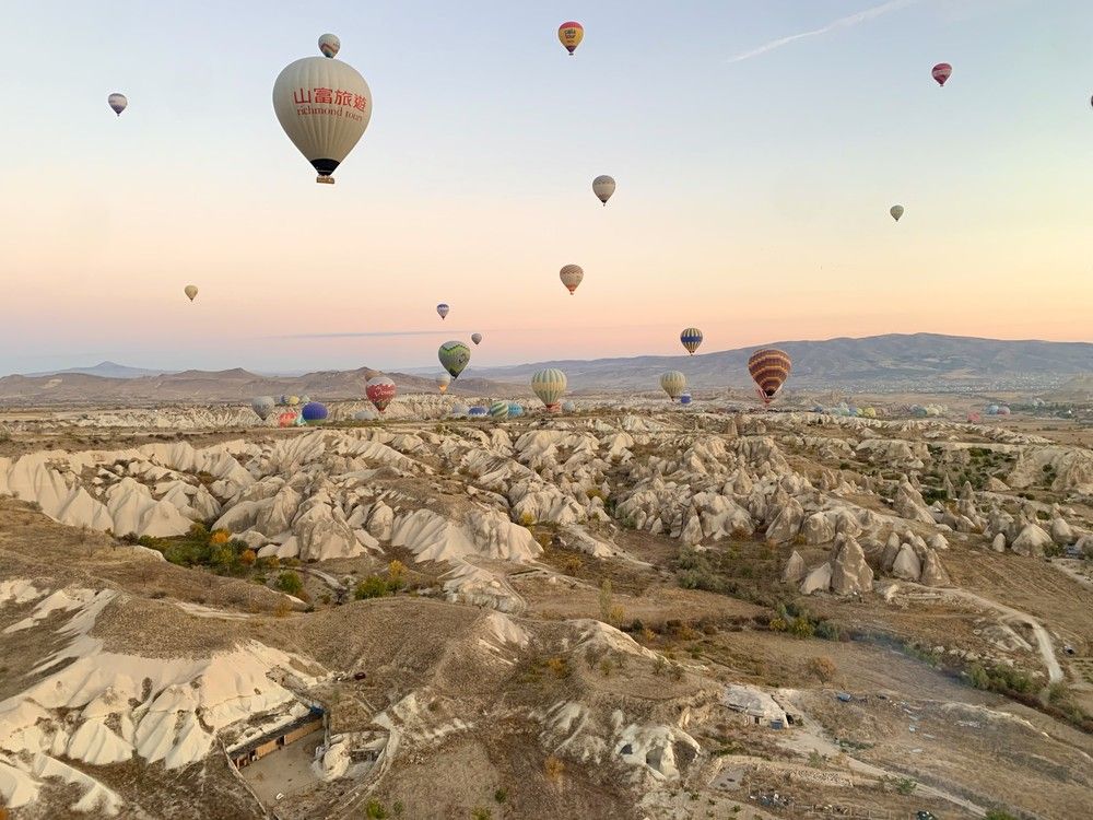 Hot air balloons launch before sunrise in Cappadocia, Türkiye.