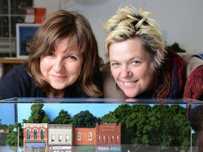 Artists Patti Normand and Lesley Buxton with Normand's Main Street of Silent Falls, from the exhibition Little Voices at Karsh-Masson Gallery in Ottawa city hall. (Photo by James Park, Ottawa Citizen)