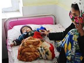 A mother comforts her baby at the Turkish government funded hospital in Sheberghan.