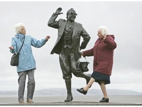 Pensioners raise a happy smile and dance next to a statue of British comedian Eric Morcambe in Morcambe, England. Experts say outdoor activity, nature, social interaction, childhood summers, positive memories, temperature and holidays are conducive to happiness.