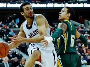 Carleton Ravens player Philip Scrubb passes the ball past University of Alberta Bears player Joel Friesen during the semi-final match of CIS Men’s Basketball Championship at Canadian Tire Centre on Saturday, March 8, 2014.