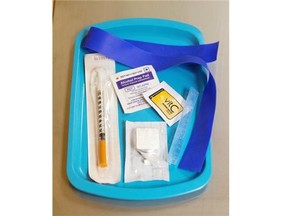 A clean, unused syringe is contained in an injection kit displayed in a mock safe injection site.