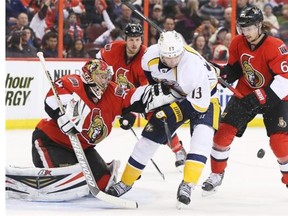Craig Anderson (L) and Erik Karlsson (R) of the Ottawa Senators battle for the puck against Nick Spaling of the Nashville Predators during second period of NHL action at Canadian Tire Centre, March 10, 2014.