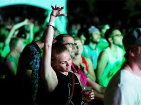 A fan enjoys the beat as the group “Tribe Called Red” works the turntables on the Black Sheep Stage as the RBC Bluesfest continued on Wednesday evening, July 10, 2013, on the grounds of the Canadian War Museum.