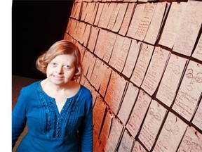 Irene Beck and her wall-sized installation piece (200 brown lunch bags), part of New Artist Showcase at SAW until April 26.