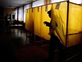 A man exits a voting booth prior to cast his vote in a local school on March 16, 2014, in Simferopol. People in Crimea took to the polls on March 16 for a referendum on breaking away from Ukraine to join Russia that has precipitated a Cold War-style security crisis on Europe’s eastern frontier. Some 1.5 million people are called to vote on the Black Sea peninsula, which is mostly inhabited by ethnic Russians and has been seized by Russian forces over the past month. A
