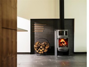 The focal point of the living room is the high-efficiency gas stove, accented with bronze panels featuring text from philosopher Martin Heidegger, a gift from architect Paul Kariouk.
