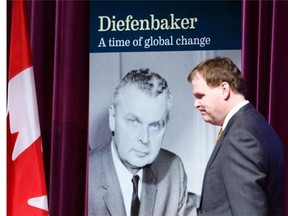 Foreign Affairs Minister John Baird walks past a photo of John Diefenbaker after Baird spoke at a foreign policy legacy meeting honouring the former Canadian prime minister in Ottawa, Thursday March 27, 2014. THE CANADIAN PRESS/Fred Chartrand