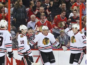 From left, Jonathan Toews, Patrick Sharp, Marian Hossa and Sheldon Brookbank of the Chicago Blackhawks celebrate Hossa’s goal against the Ottawa Senators during second period of NHL action at Canadian Tire Centre in Ottawa, March 28, 2014.