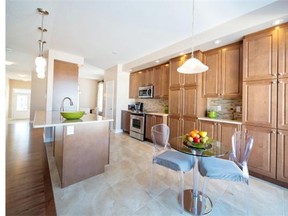 The Loire kitchen includes ceiling-high upper cabinetry in a warm maple finish, a flush breakfast bar and an extended pantry.